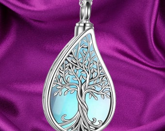 May include: A silver teardrop-shaped pendant necklace with a tree of life design. The pendant has a blue and green gradient color.