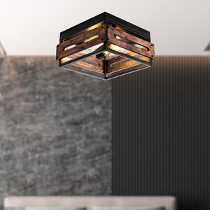 May include: A modern farmhouse style ceiling light fixture with a black metal frame and wood accents. The light fixture has a square shape and is hanging from the ceiling in a bedroom setting.