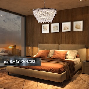 May include: A crystal chandelier with a brown metal frame hangs above a bed with a beige headboard and orange bedding. The room has a wooden wall and a window with a view of a city skyline at sunset. The text "Warmly Shades" is visible in the lower left corner of the image.