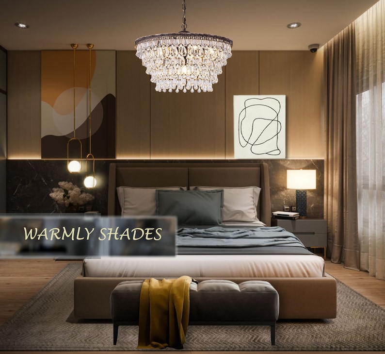 May include: A crystal chandelier with a brown metal frame hangs above a bed in a bedroom with warm brown walls. The bed has a brown headboard and a beige duvet. The room has a rug with a geometric pattern and a small ottoman with a yellow throw blanket.