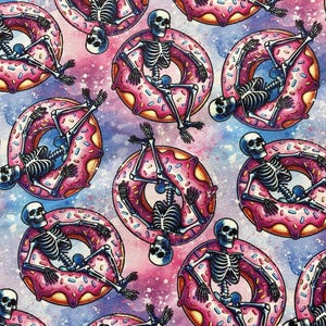 May include: A repeating pattern of skeletons sitting in pink and white frosted donuts against a galaxy-like background.