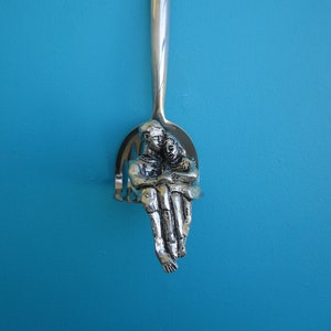 Young Love Mash - a beautiful little Cornish pewter sculpture of a young couple holding hands while sitting on a potato masher.