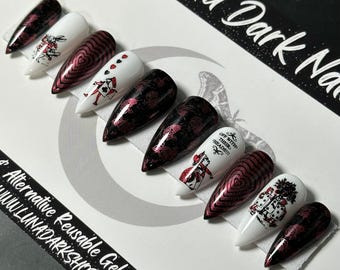 May include: A set of alternative reusable gel press-on nails. The nails feature various designs, including a red and black floral pattern, playing card illustrations, and the text "OFF WITH THEIR HEADS!!!". The nails are in a variety of shapes.