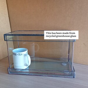 May include: White ceramic mug with a black handle, featuring the text "But First, Coffee" in black. The mug is displayed against a blurred backdrop, implying a comfortable environment.