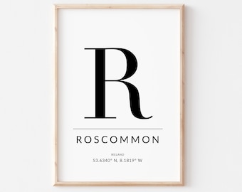 May include: A framed print with a black letter "R" and the text "Roscommon, Ireland 53.6340° N, 8.1819° W".