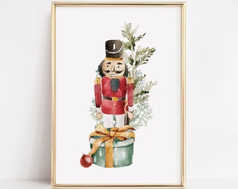 May include: A watercolour painting of a nutcracker soldier standing on a green gift box with a gold ribbon. The nutcracker is wearing a red and gold uniform and a black hat. A green pine branch with white berries is behind the nutcracker.
