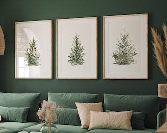 Pode incluir: Um sofá seccional de veludo verde com três almofadas, uma cesta tecida e uma mesa de centro de madeira com um livro em cima. O sofá está em frente a uma parede verde com três pinturas de aquarela emolduradas de árvores.