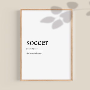 May include: A black and white printable wall art print with the word "soccer" in bold font, the phonetic pronunciation, and the phrase "the beautiful game".