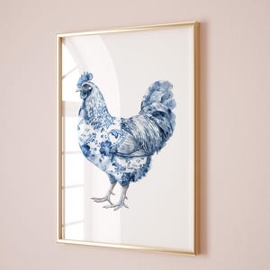 以下が含まれることがあります： 青い花柄の青い白い雄鶏の水彩画が額装されています。雄鶏は白い背景に立っています。