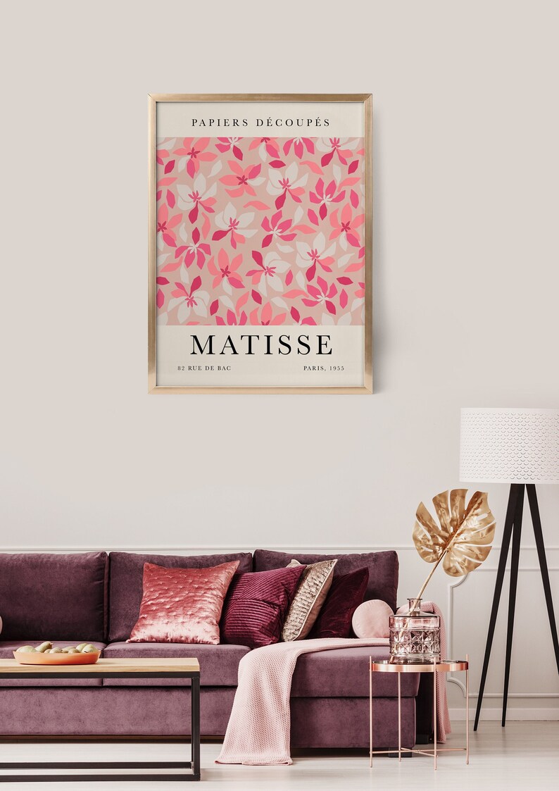 May include: A framed print of a pink and white floral design with the text "PAPIERS DECOUPES" and "MATISSE" in black. The text below the floral design reads "82 RUE DE BAC PARIS, 1955".