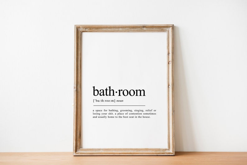 May include: A framed print with a black and white definition of the word "bathroom". The definition reads: "['ba:th:room] noun a space for bathing, grooming, singing, relief of losing your shit. a place of contention sometimes and usually home to the best seat in the house."
