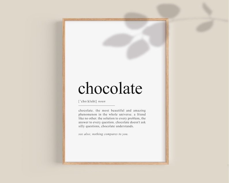 May include: A black and white printable wall art print with the word "chocolate" defined as "the most beautiful and amazing phenomenon in the whole universe." The print is framed in a light brown wood frame.