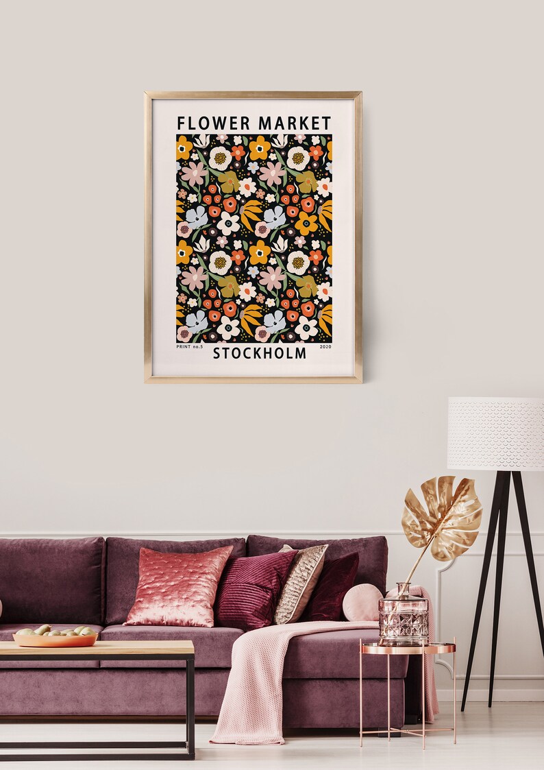 May include: A framed print with a floral pattern in shades of yellow, orange, pink, and blue on a black background. The print has the text "FLOWER MARKET" and "STOCKHOLM" in white.