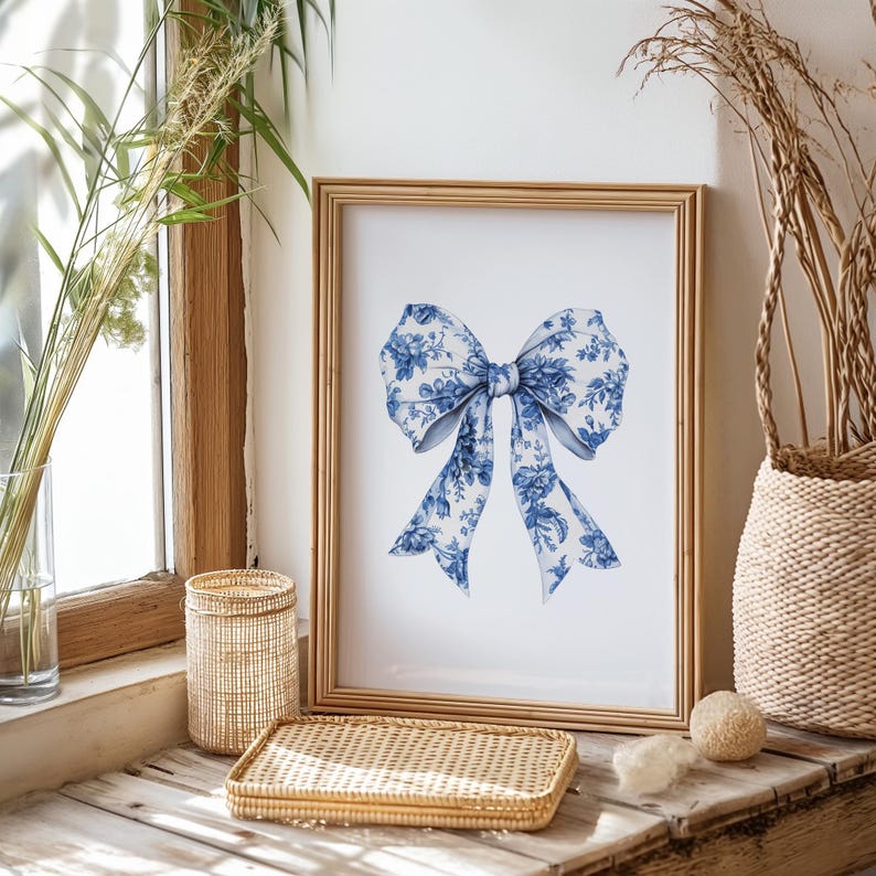 Puede incluir: Una impresi&oacute;n enmarcada de un lazo floral azul y blanco. El lazo est&aacute; atado en un estilo cl&aacute;sico y tiene un toque delicado y femenino. La impresi&oacute;n es perfecta para agregar un toque de elegancia a cualquier habitaci&oacute;n.