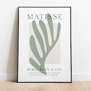 Op de afbeelding: Een zwart-witte poster met de tekst "MATISSE" bovenaan en "BERGGRUEN & CIE" onderaan. De poster heeft een groen abstract bladontwerp.