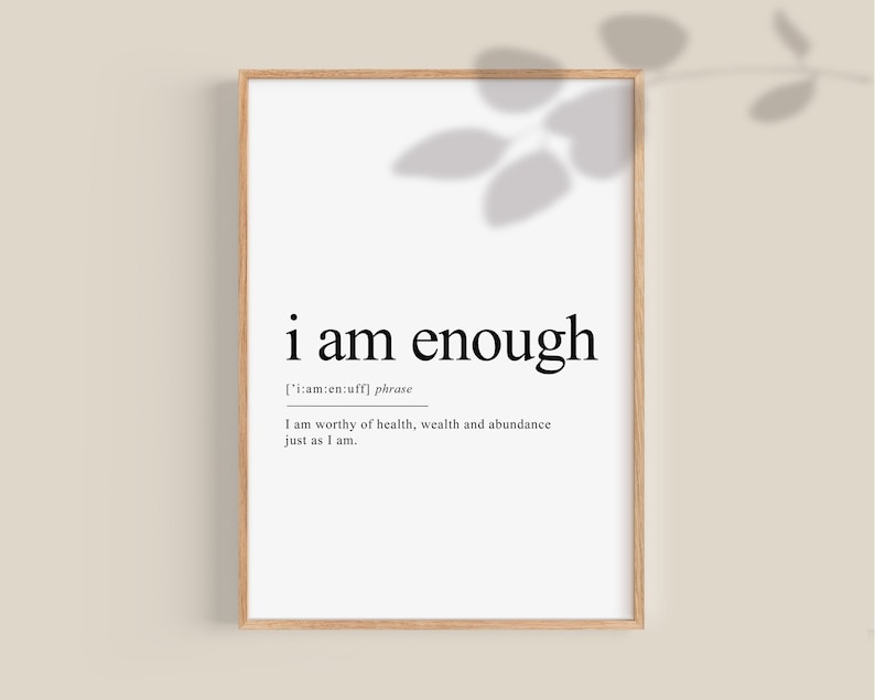 K&ouml;nnte beinhalten: Ein schwarz-wei&szlig;er druckbarer Wandkunstdruck mit dem Text "i am enough" und einer Definition des Ausdrucks. Der Druck ist in einem hellen Holzrahmen gerahmt.