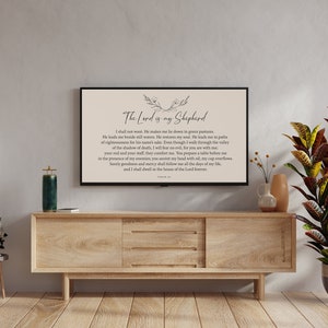 Puede incluir: Una impresi&oacute;n enmarcada con fondo beige y texto negro. El texto dice "El Se&ntilde;or es mi Pastor" e incluye un pasaje del Salmo 23. La impresi&oacute;n est&aacute; colgada en una pared sobre un armario de madera.