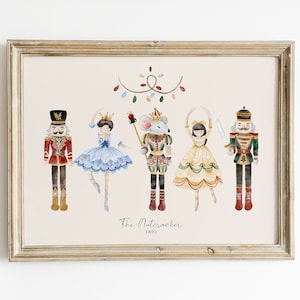 Könnte beinhalten: Eine Aquarell-Illustration von Figuren aus dem Ballett Nussknacker. Die Illustration zeigt einen Nussknacker-Soldaten, eine Ballerina, einen Mäusekönig und zwei Ballerinas. Die Illustration ist in einem hellen Holzrahmen gerahmt und hat einen hellrosa Hintergrund.