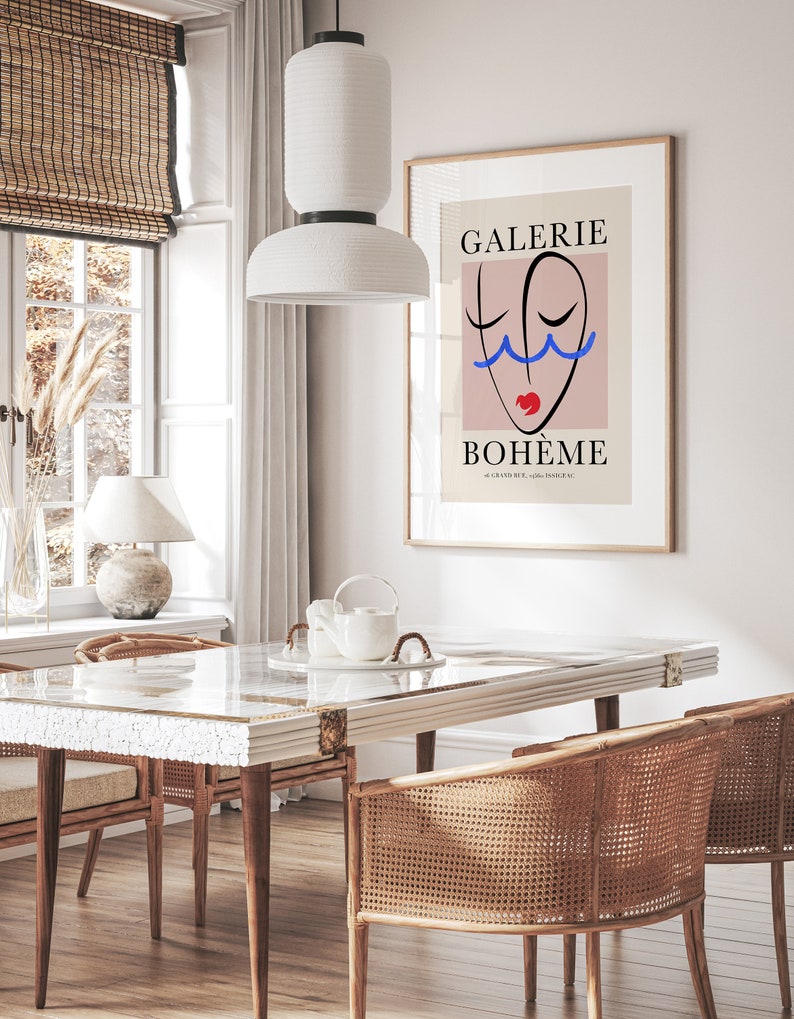May include: A minimalist poster with a pink background and a black line drawing of a face with blue and red accents. The text "GALERIE BOHEME" is printed in black at the top and bottom of the poster.