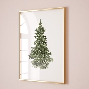 Puede incluir: Una pintura de acuarela enmarcada de un pino verde sobre un fondo blanco. El marco es dorado.