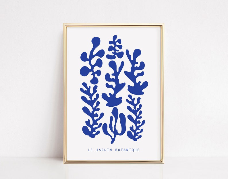 May include: A framed print with a blue abstract design of stylized plants. The text "LE JARDIN BOTANIQUE" is at the bottom of the print.