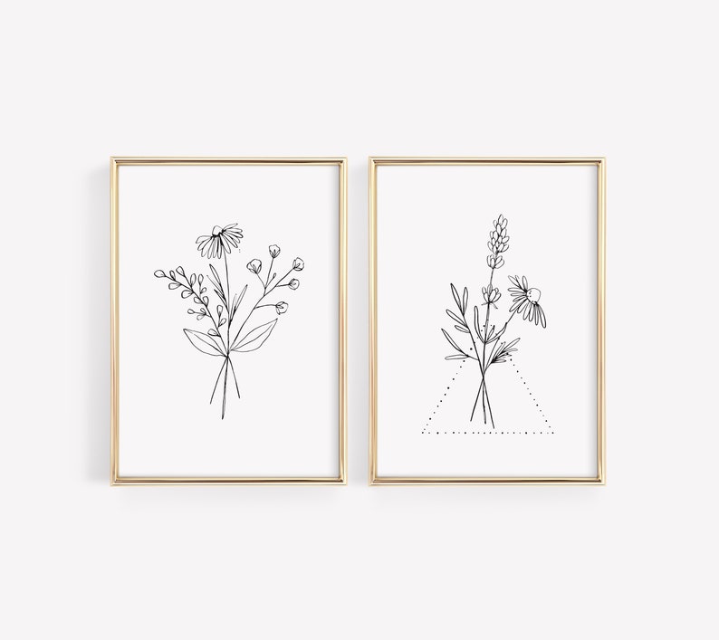 May include: Two black and white line drawings of floral bouquets in gold frames. The first bouquet features a daisy and other wildflowers. The second bouquet features a daisy, lavender, and other wildflowers.