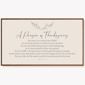 May include: A beige printable wall art print with a brown wood frame. The print features a prayer of thanksgiving with a floral design and the text "A Prayer of Thanksgiving" and "Oh come, let us sing to the LORD! Let us shout joyfully to the Rock of our salvation. Let us come before His presence with thanksgiving; let us shout joyfully to Him with psalms. For the LORD is the great God, and the great King above all gods. In His hand are the deep places of the earth' the heights of the hills are His also. The sea is His, for He made it; and His hands formed the dry land. -PSALM 95:1-5"