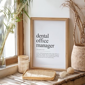 May include: A black and white printable art print with the text "dental office manager [the goat] noun" and a definition of the term. The print is framed in a light wood frame and is sitting on a wooden surface.