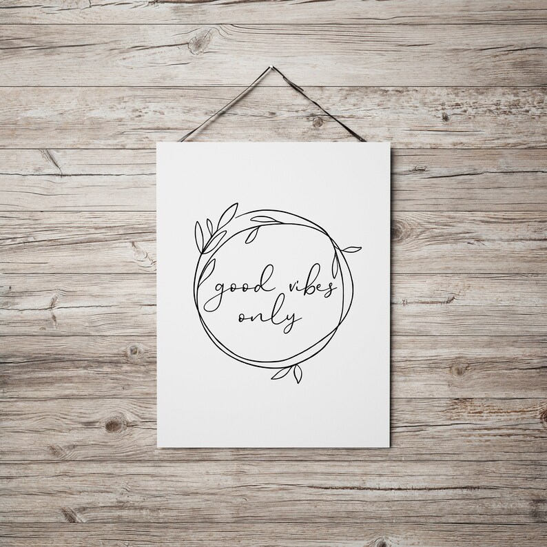 May include: A white printable poster with a black line drawing of a wreath with leaves and the text "good vibes only" inside.