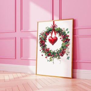 May include: A watercolor painting of a red heart wreath with green leaves hanging on a white background. The wreath is surrounded by smaller red hearts.