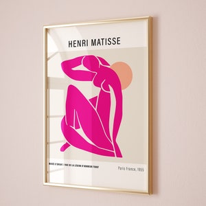 May include: A framed print of a pink abstract figure by Henri Matisse. The print is titled "MUS&Eacute;E D'ORSAY I RUE DE LA LEGION D'HONNEUR 75007" and "Paris France, 1955".