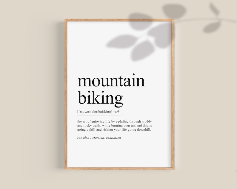 Op de afbeelding: Een zwart-witte printbare poster met het woord "mountainbiken" gedefinieerd als "de kunst van genieten van het leven door te fietsen over modderige en rotsachtige paden, terwijl je je kont en dijen verbrandt, bergop gaat en je leven riskeert om bergaf te gaan." De poster bevat ook de tekst "zie ook: uithoudingsvermogen, extase".
