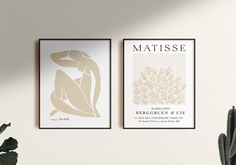 May include: Two framed art prints with a minimalist aesthetic. The print on the left features a beige outline of a seated figure. The print on the right features a beige outline of a cluster of leaves with the text "MATISSE" and "La Gerbe (1953)" at the top and "BERGGRUEN & CIE" and "70, RUE DE L'UNIVERSITE, PARIS-VII" at the bottom.