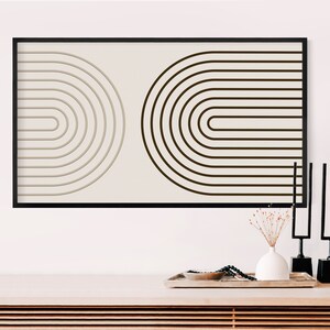 K&ouml;nnte beinhalten: Ein gerahmter abstrakter Kunstdruck mit zwei bogenf&ouml;rmigen Designs. Ein Bogen ist hellbeige, der andere dunkelbraun, beide auf cremefarbenem Hintergrund. Das Kunstwerk wird &uuml;ber einem Holztisch mit dekorativen Gegenst&auml;nden ausgestellt.