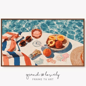 Peut inclure: Une impression d'art numérique encadrée représentant une piscine avec un verre de vin rosé, des pêches coupées sur une assiette, des lunettes de soleil, une serviette rayée, un tube de crème solaire, des cartes à jouer et un chapeau de paille.