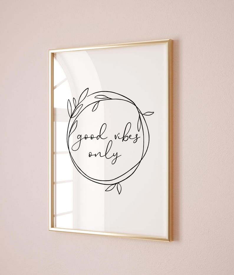 May include: A framed print with a white background and black text that reads "good vibes only" inside a circle with a floral design.