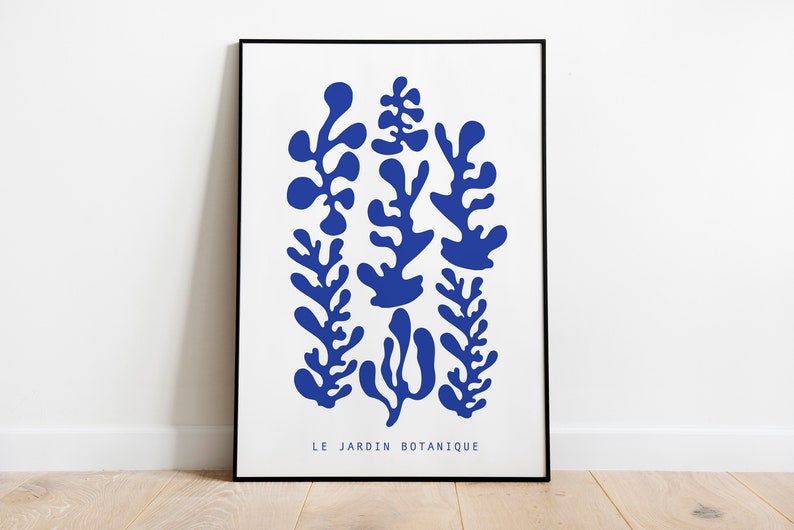May include: A framed print with a blue abstract design of stylized plants. The text "LE JARDIN BOTANIQUE" is at the bottom of the print.