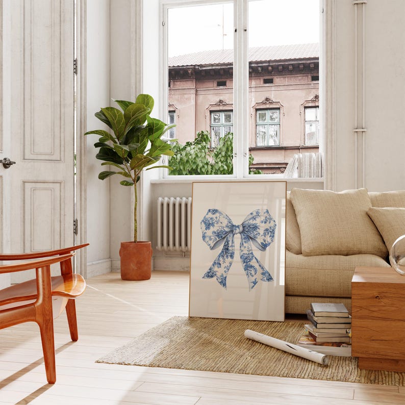 Puede incluir: Una impresi&oacute;n enmarcada de un lazo con estampado floral azul y blanco sobre fondo blanco. La impresi&oacute;n est&aacute; colgada en una pared blanca en un sal&oacute;n.
