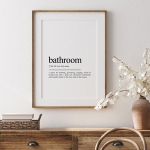 May include: A framed print with a black and white definition of the word "bathroom". The definition reads: "['bath room] noun a space for bathing, grooming, singing, relief or losing your shit, a place of contentment sometimes and usually home to the best seat in the house."