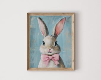 Op de afbeelding: Een schilderij van een wit konijn met roze oren en een roze strik. Het konijn kijkt recht naar de kijker. De achtergrond is lichtblauw.