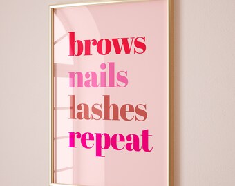 May include: A gold framed print with a pink background and the text "brows nails lashes repeat" in pink, red, and orange.