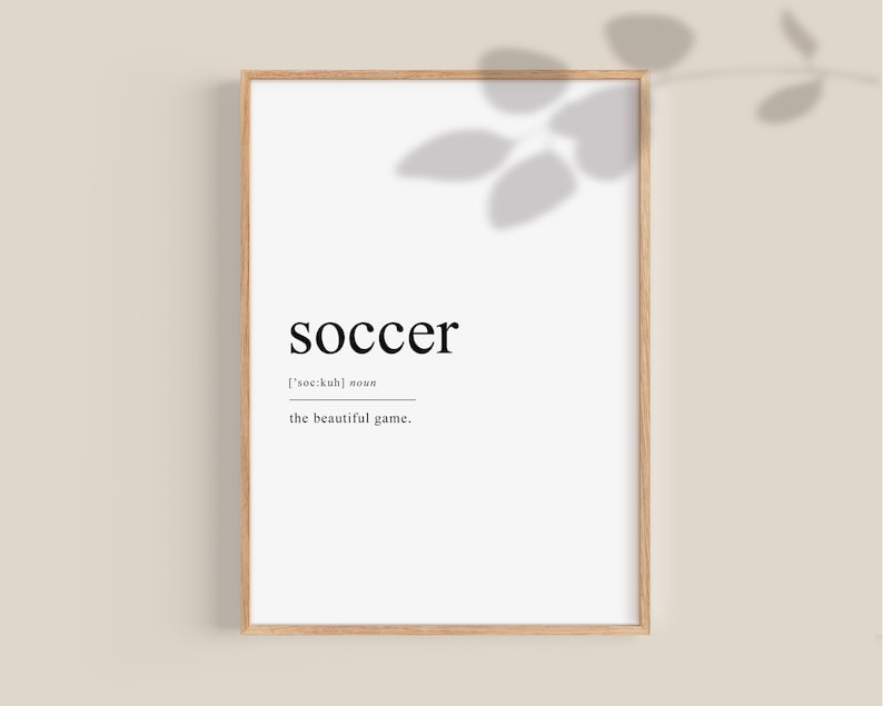 May include: A black and white printable wall art print with the word "soccer" in bold font, the phonetic pronunciation, and the phrase "the beautiful game".