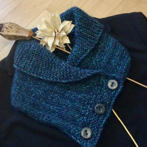 Peut inclure: Un col en tricot bleu et vert avec un large col et trois boutons. Le col est fait d'un fil doux et texturé.