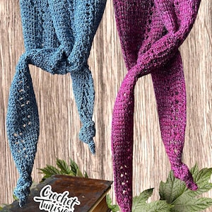 May include: Two handmade crochet scarves, one teal and one magenta, are displayed against a wooden background. The scarves are knotted at the bottom and have a delicate, openwork design. The image also includes a vintage book and greenery.