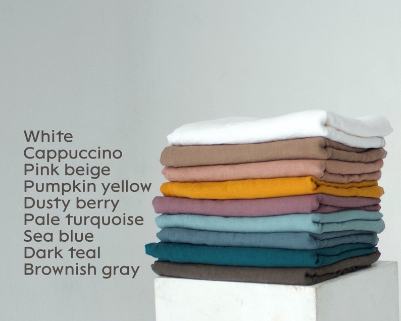 May include: A stack of folded linen fabric in various colors, including white, cappuccino, pink beige, pumpkin yellow, dusty berry, pale turquoise, sea blue, dark teal, and brownish gray. The colors are listed in a column on the left.