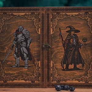 Può includere: Una scatola di legno con un coperchio incernierato, che presenta illustrazioni di un cavaliere e un mago. La scatola è chiusa e ha una chiusura in metallo. Ci sono sei dadi neri davanti alla scatola.