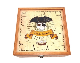 Puede incluir: Una caja de madera con un diseño de tesoro pirata. La caja tiene una tapa con bisagras y un cierre de metal. El diseño presenta una calavera con un parche en el ojo y un sombrero de pirata, un barco y las palabras "Pirate treasure".