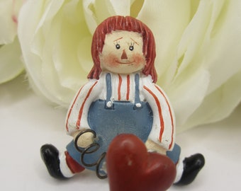 Raggedy Ann con broche de corazón rojo primaveral