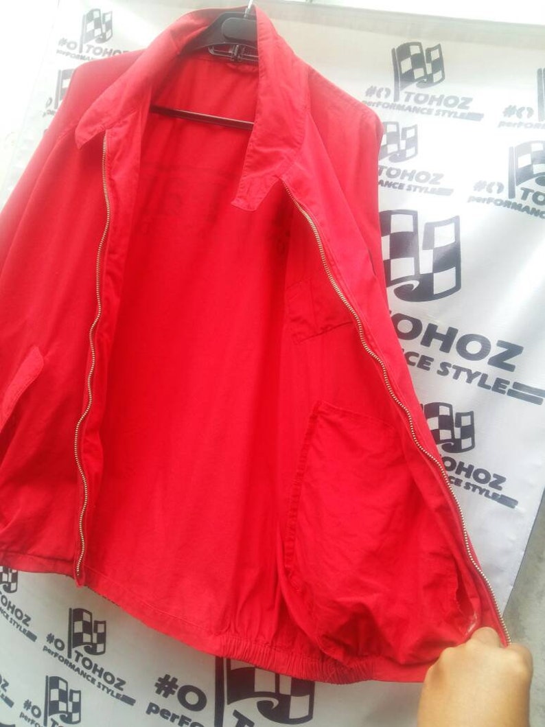 K&ouml;nnte beinhalten: Eine rote Rei&szlig;verschlussjacke mit Kordelzug und einer Tasche auf der linken Seite.