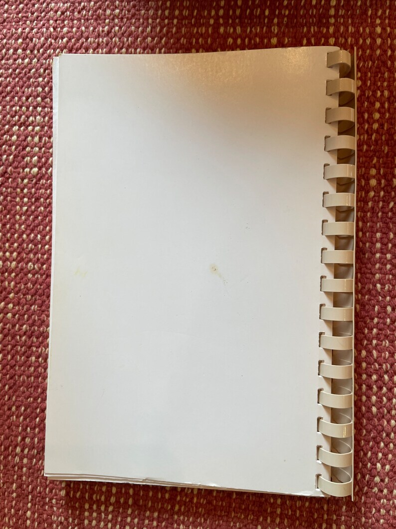 Może przedstawiać: Biały, pusty notes w spirali z białym plastikowym oprawieniem.